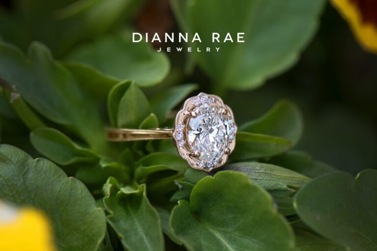 Model wearing Daisy Blossom oval diamond engagement ring in yellow gold, showcasing delicate milgrain halo and floral-inspired setting