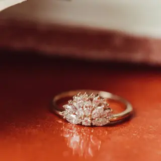 Elegant flat lay of The Luna Band engagement ring featuring 0.60ct marquise and round diamonds arranged in a unique fan shape on a 14k gold band