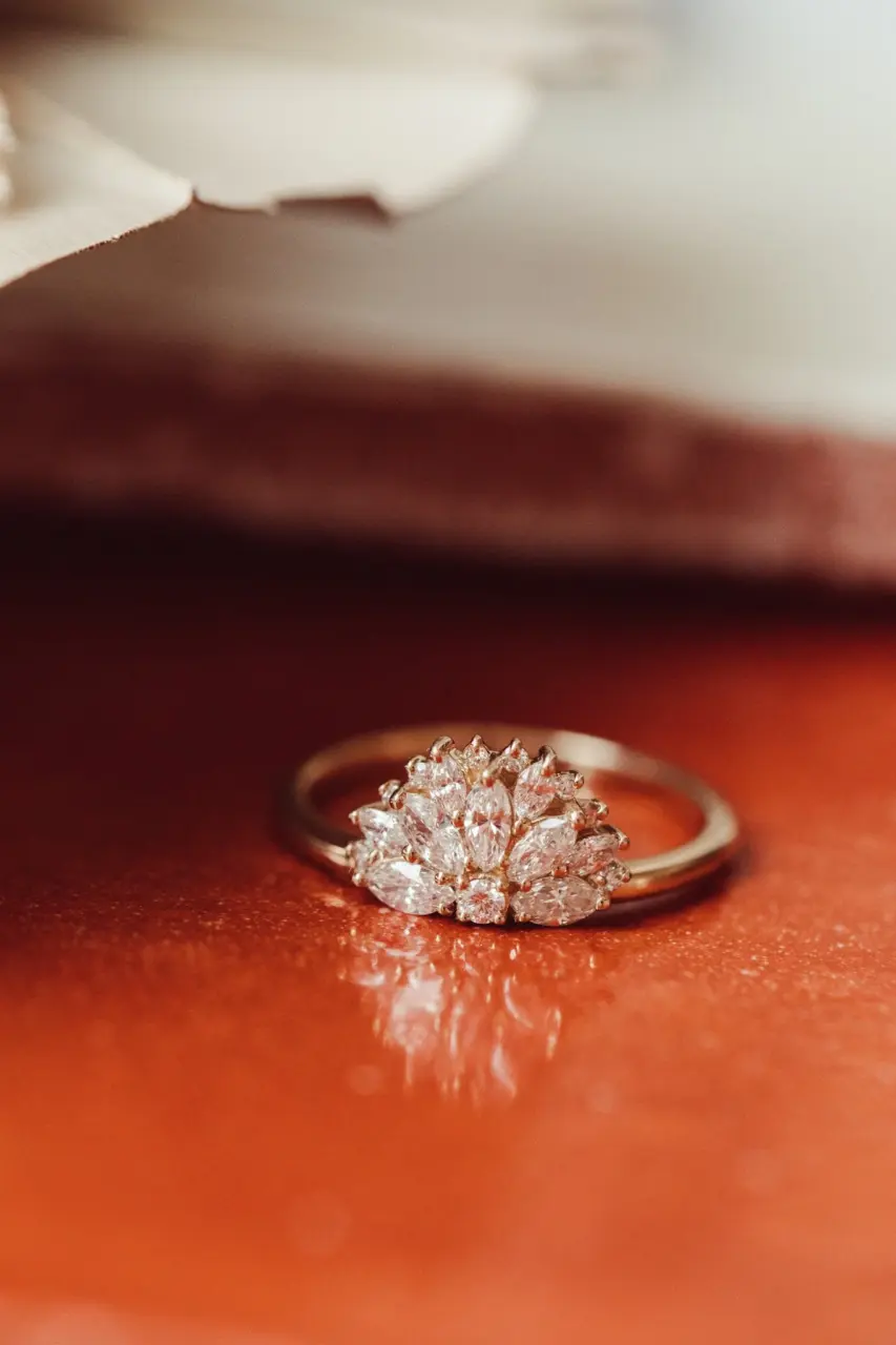 Elegant flat lay of The Luna Band engagement ring featuring 0.60ct marquise and round diamonds arranged in a unique fan shape on a 14k gold band