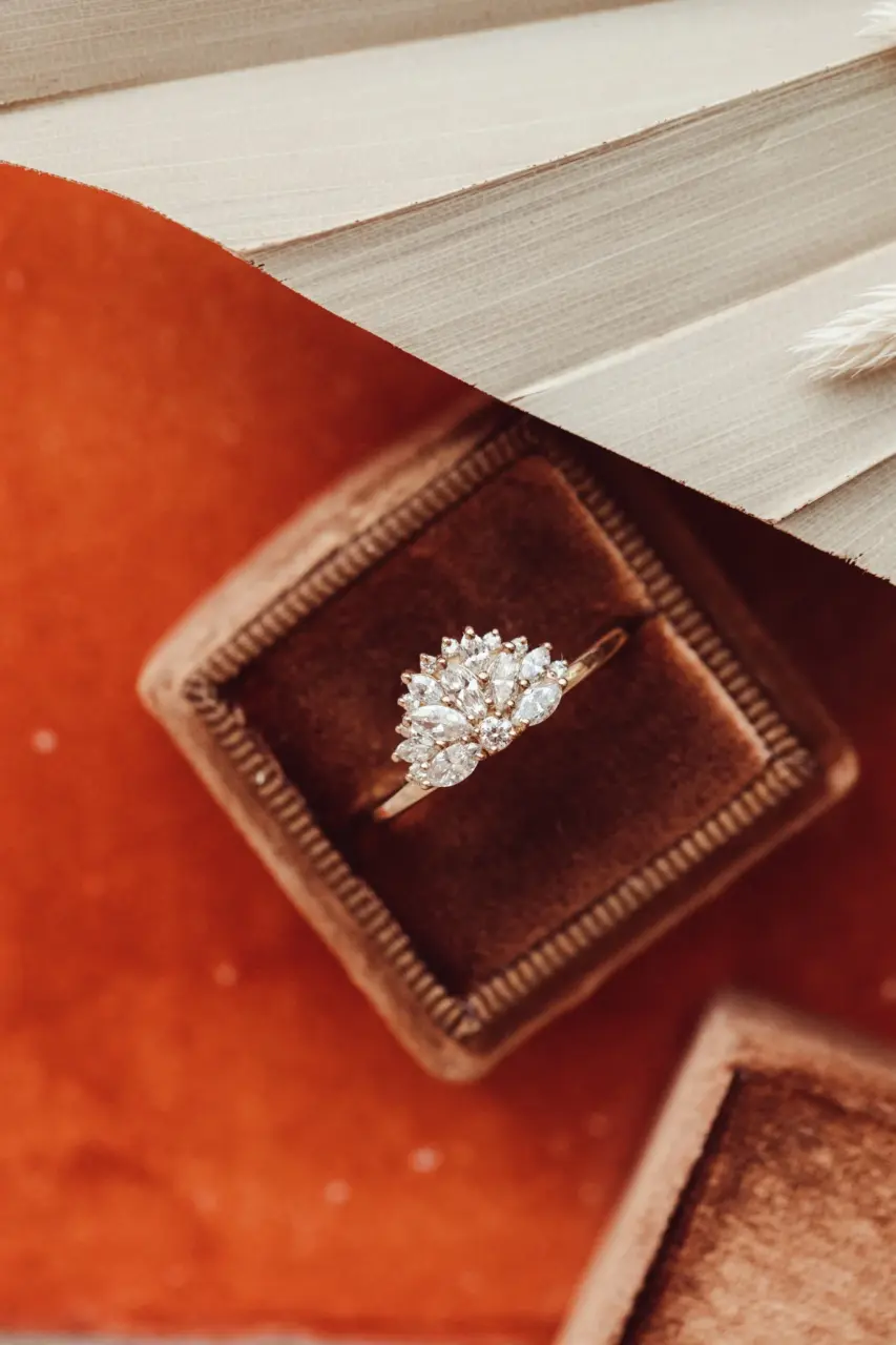 Side profile of The Luna Band engagement ring, showcasing marquise and round diamonds in a half-moon fan design set in recycled 14k gold