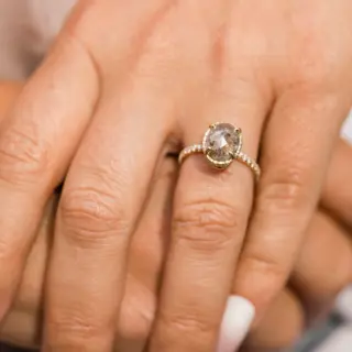 Side profile of the Destiny engagement ring, emphasizing the hammered texture of the halo setting and the sleek 14k recycled yellow gold band.