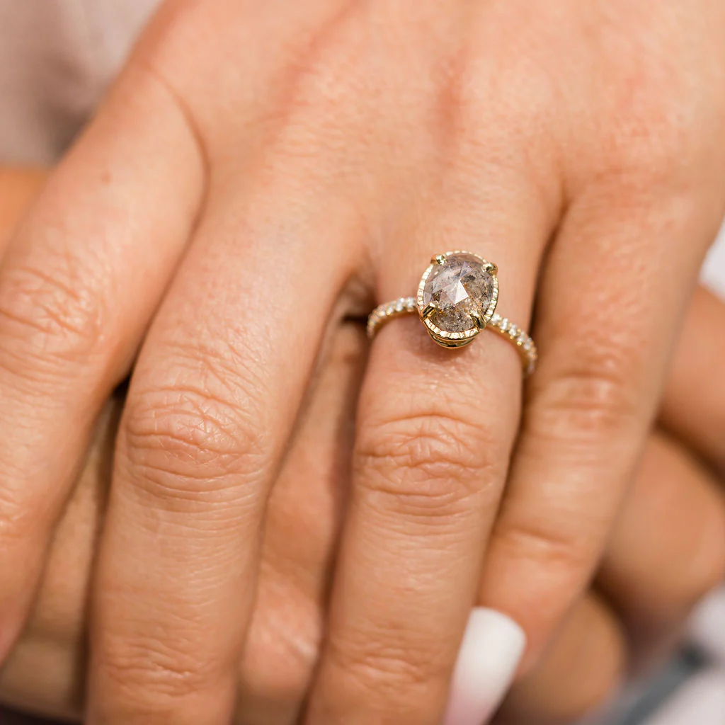Side profile of the Destiny engagement ring, emphasizing the hammered texture of the halo setting and the sleek 14k recycled yellow gold band.