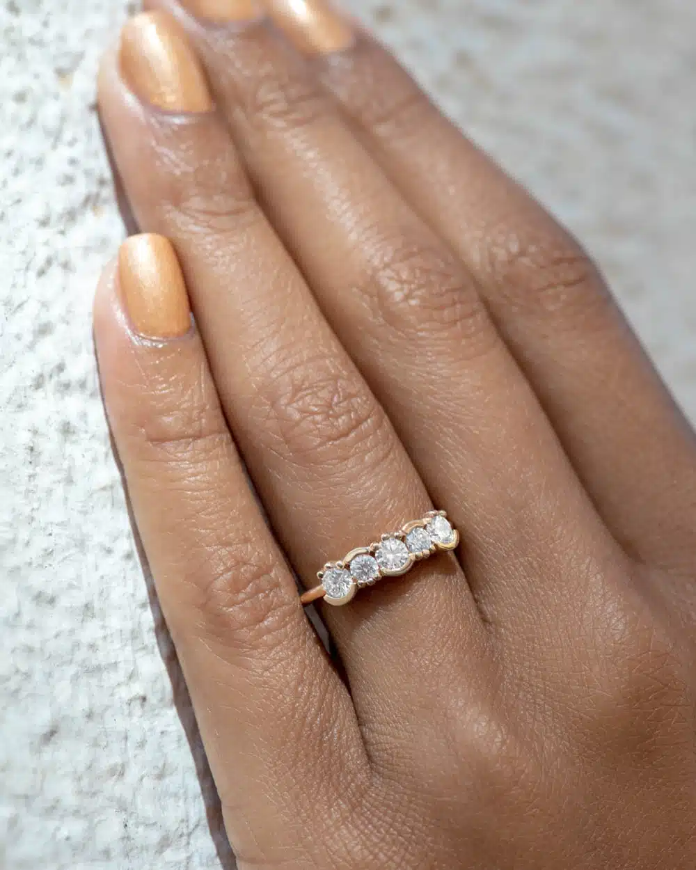 Side view of the Lash Linear Ring—delicate 1.6 mm gold band supporting a linear array of mixed bezel and prong-set diamonds.