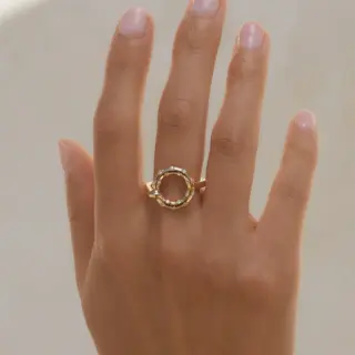 Close-up side angle of the Aria Ring showing its slim yellow-gold band and the diamond-studded face.