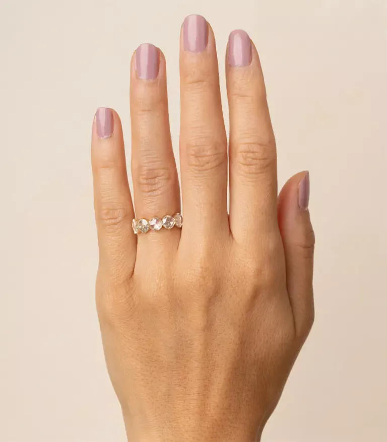 Close-up of textured yellow gold wedding band with five rose‑cut diamonds set with milgrain edging and subtle dark rhodium accents