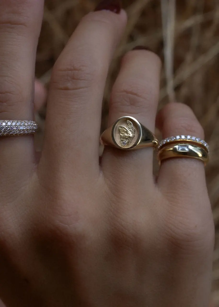 Close-up of Kinn Studio's Juliette Butterfly Signet Ring showcasing the intricate butterfly wing design and sparkling round diamond set in 14k gold