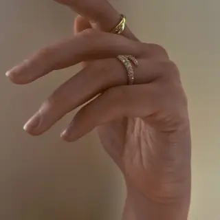 Side profile of Kinn Studio’s wrap-around diamond ring—wide front tapering elegantly toward the back.