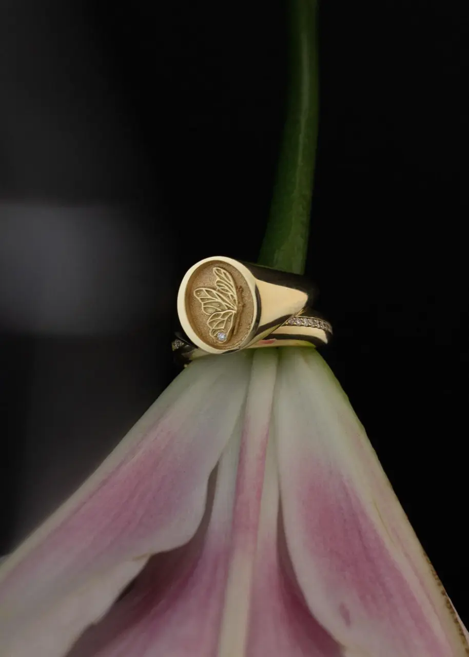 Lifestyle image of the Juliette Butterfly Signet Ring by Kinn Studio worn on the hand, emphasizing its minimalist design and symbolic engraving.