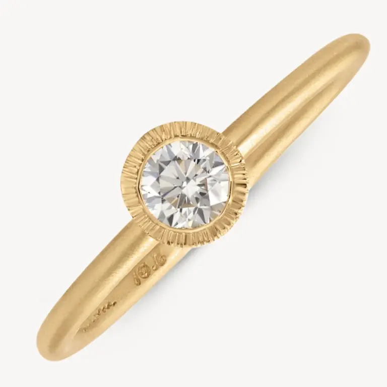 Audry Rose 18k Brushed Bezel Diamond Solitaire Ring featuring a 0.24ct round white diamond set in a matte yellow gold band.