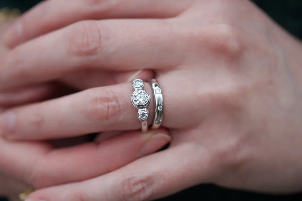 Lifestyle image of the Three Stone Diamond Engagement Ring worn on the hand, emphasizing its elegant design and sparkling diamonds