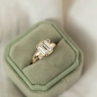 Side profile of the Indigo Emerald Ring, emphasizing the smooth 3.7mm domed band and the elegant design.