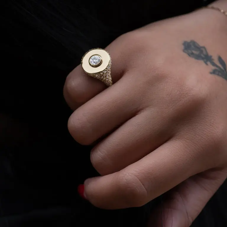 Side view of Anna Sheffield’s All-Seeing Signet Ring, showcasing the intricate pavé diamond detailing and polished yellow gold finish
