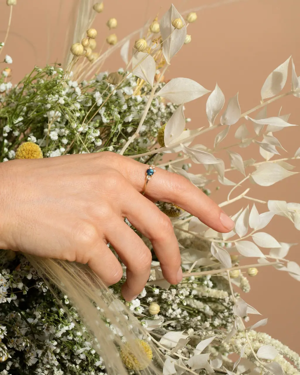 Cluster ring by Mociun featuring 0.47 ct Montana blue sapphire, peach sapphires, and diamonds in 18K gold