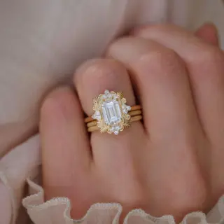 Elegant moissanite engagement ring with diamond detailing and intricate Florentine design