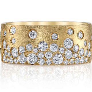 The Scattered Diamond Wide Cigar Band worn on hand, illustrating its bold presence and the sparkling white diamonds set in the 14K yellow gold band.