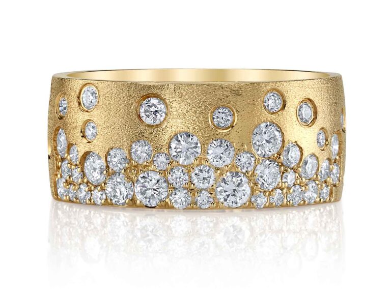 The Scattered Diamond Wide Cigar Band worn on hand, illustrating its bold presence and the sparkling white diamonds set in the 14K yellow gold band.