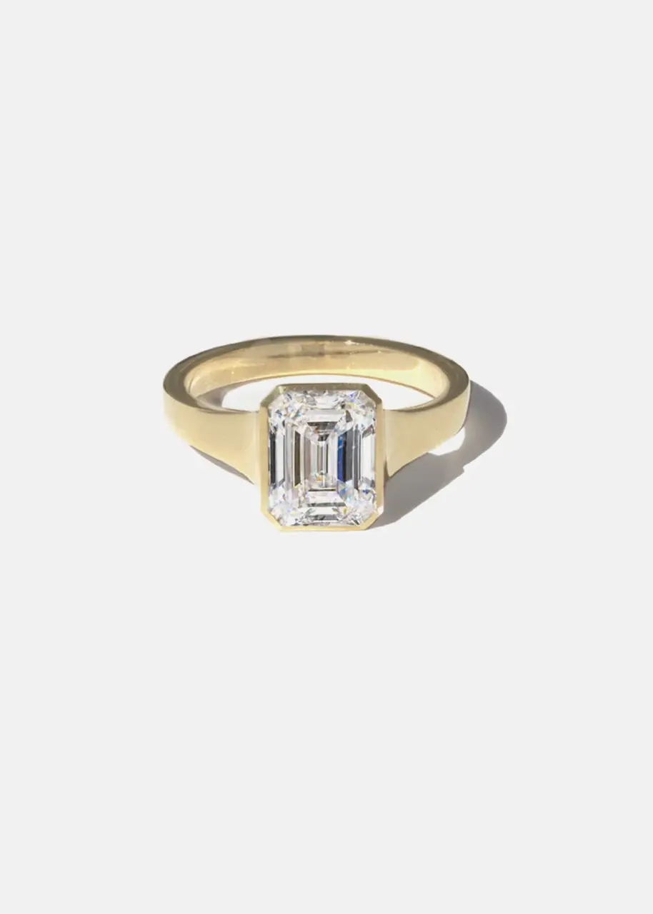 Emerald Diamond Cosma Ring in polished 18 k gold, featuring a sleek emerald‑cut diamond bezel set in an octagonal silhouette