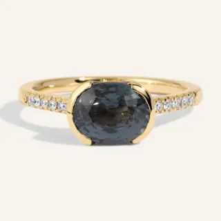 Detailed view of the Estrada Ring: a 2.31 ct dark gray‑blue spinel mounted side‑to‑side in a half‑bezel 14k gold setting, enhanced by a row of .09 ctw SI G‑H diamonds covering half the band