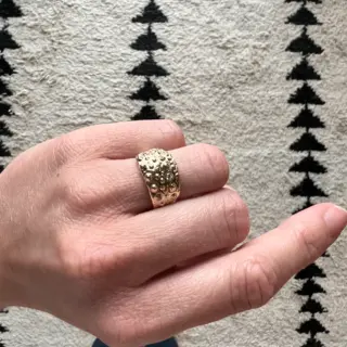 Unique textured gold ring with undulating, natural-inspired form and matte finish.