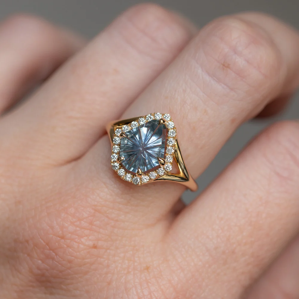 Model wearing Anueva Jewelry's 2.34ct fantasy cut carved shield Montana sapphire ring in 14k yellow gold, showcasing its unique design and radiant gemstone