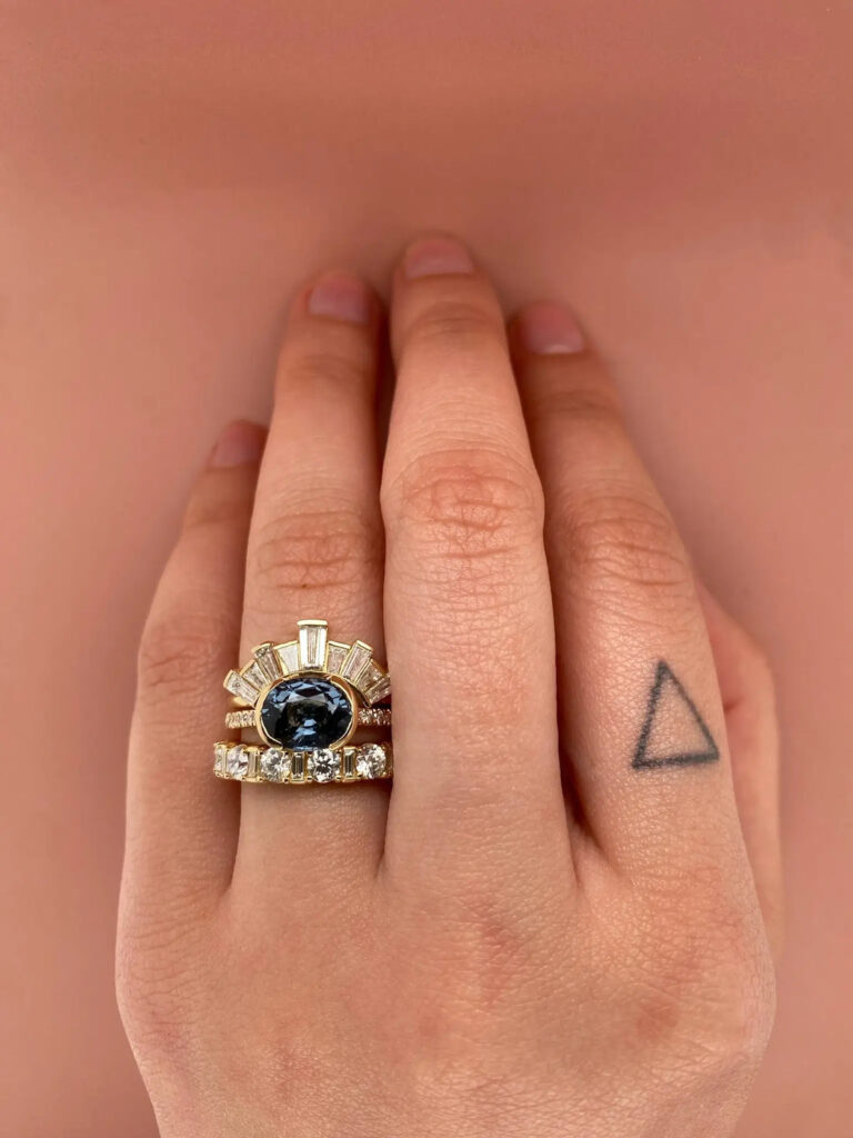 Elegant Estrada engagement ring displaying a rich 2.31 ct gray‑blue spinel set east‑west in a delicate 14k bezel, complemented by a half‑band of sparkling .09 ctw SI G‑H diamonds for balanced contrast.”