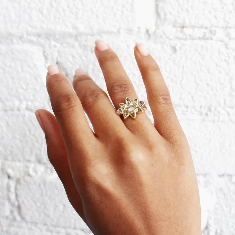 Lauren Wolf Jewelry Sunrise Ring featuring marquise-cut gray-green diamond, surrounded by pear and trillion-cut salt-and-pepper diamonds in 18k yellow gold.