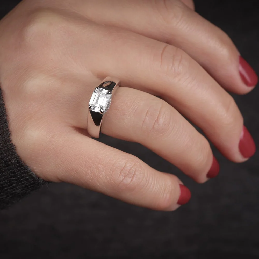 The Love Manifesto Band worn on hand, illustrating its bold and elegant design in 14K gold with an emerald-cut diamond and pavé accents.