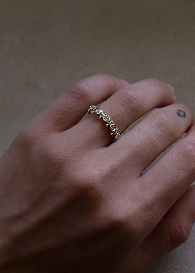 Side profile of the 5‑Stone White Diamond Koemi Ring, highlighting the square‑band silhouette and rhythmic peak‑to‑valley bead detailing in eco‑friendly 14k gold