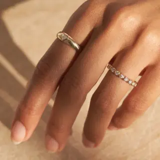 Side view of lab-grown diamond engagement ring with elongated cushion cut and two-tone gold band.