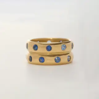 Angled image of the Half Round Mosaic Band highlighting the flush-set sapphires and the soft, warm tone of 20K custom peach gold.