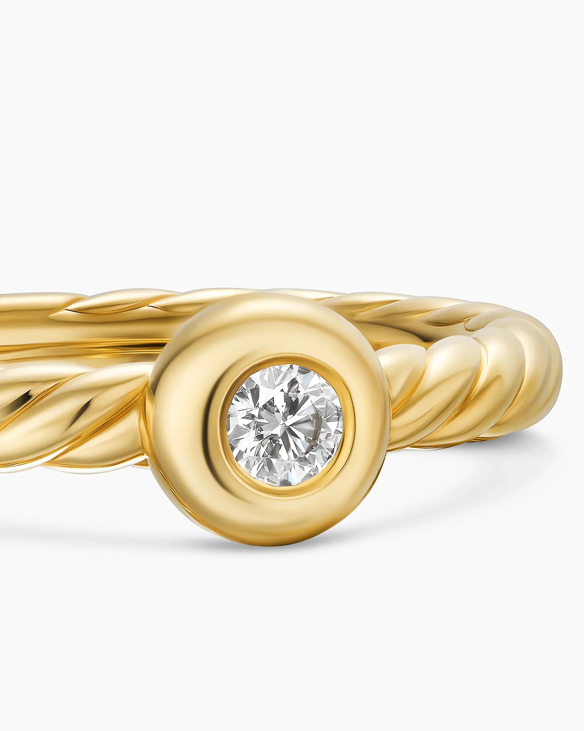 The Petite Cable Ring worn on hand, illustrating its delicate design and the sparkling 2.8mm diamond set in 18K yellow gold.