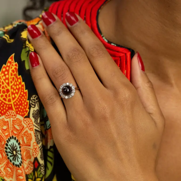 Vintage ring with glowing garnet cabochon and a diamond halo of 12 Old‑Mine‑cut stones set in two‑tone sterling silver and yellow gold