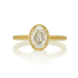 1.5 ct oval diamond Art Deco engagement ring in 14k gold, featuring milgrain detail, angular openwork basket, and six blue sapphires set into the filigree for vintage elegance