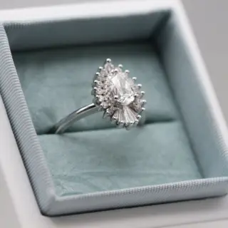 Heidi Gibson's Rhapsody 15mm ring displayed on a stand, showcasing its luxurious design and sparkling natural diamonds in 14k white gold