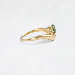 Side profile of the Astronomer Ring featuring layered setting of surrounding diamonds and a domed 14k yellow gold band.