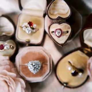 Timeless vintage engagement ring showcasing a 0.80ct pear-cut diamond encircled by a ruby baguette halo and diamond-accented shoulders, set in platinum and 18kt yellow gold.