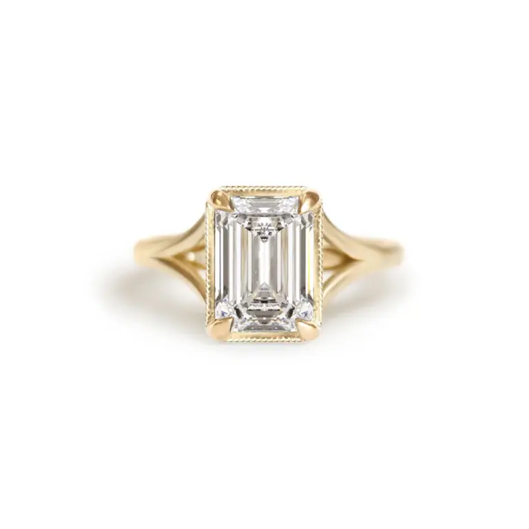 Split‑shank solitaire ring in 14K yellow gold featuring an emerald‑cut lab‑created diamond (~0.50 cttw, F color, VS clarity), flanked by tapered baguette and round brilliant accent diamonds (~0.75 cttw)