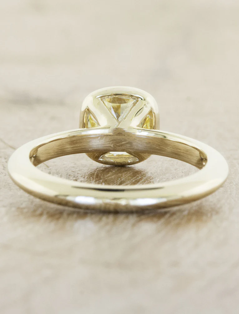 Unique bezel-set solitaire engagement ring with oval diamond, perfect for a modern and stylish proposal.