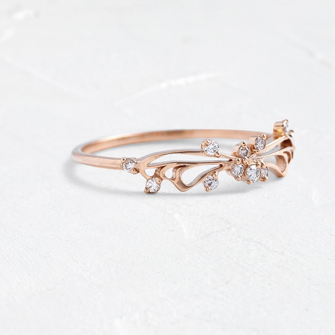 Side profile of Diamond Small Changes Ring in 14k gold, revealing the graceful layered swoops and refined setting of naturally sourced accent diamonds along the band.