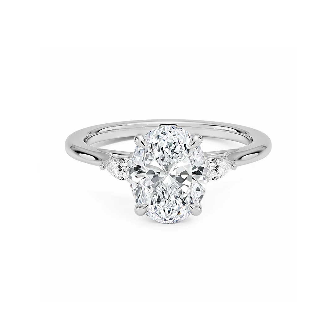 Lab diamond three-stone ring with gold band and pear side stones.