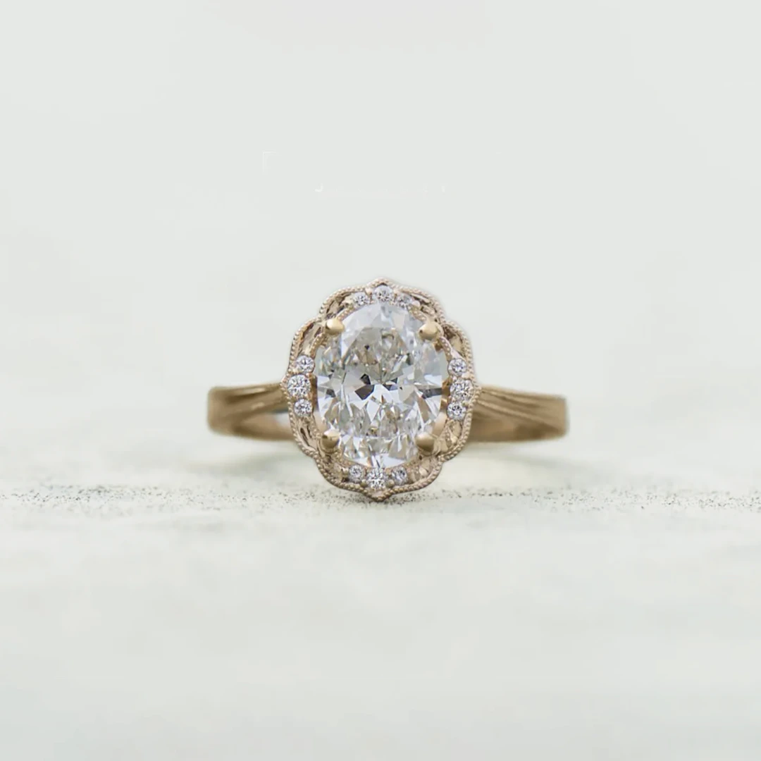 14k yellow gold Daisy Blossom engagement ring with 1.16 carat oval lab-grown diamond and halo of twelve accent diamonds with milgrain detail.