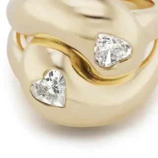 18K yellow gold ring with two heart-shaped diamonds in a knot design.
