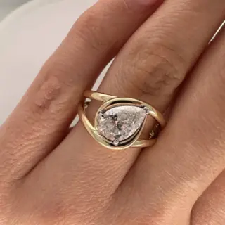 Model wearing Orianne Jewelry's 1.54 carat pear diamond knot ring in 14k yellow gold, showcasing its elegant design and radiant diamond