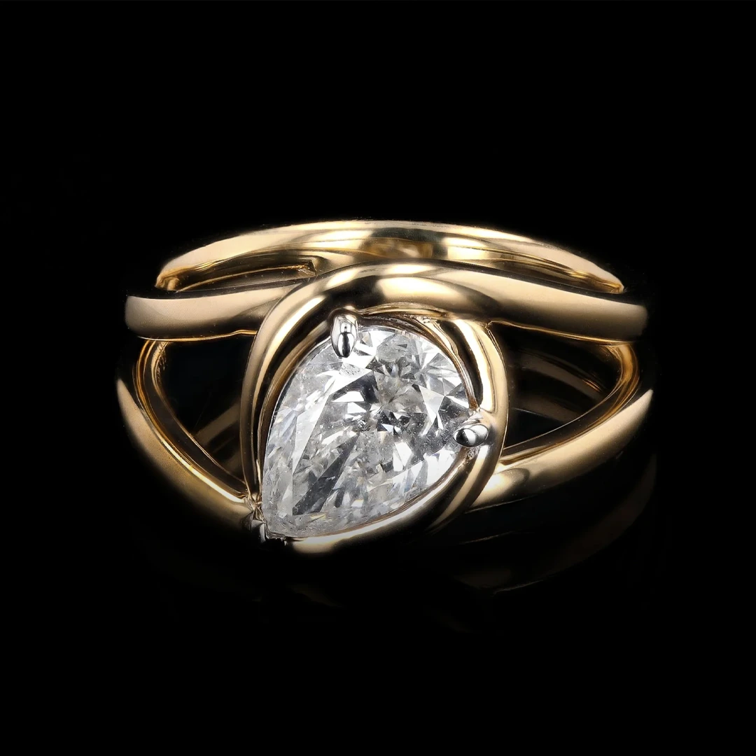 Orianne Jewelry's 1.54 carat pear diamond knot ring displayed on a stand, emphasizing its luxurious design and fine craftsmanship