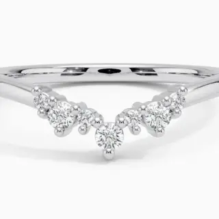 Close-up of 18 K white gold Aubrey ring with curved band and seven small round prong-set diamonds (0.11 ct total weight)