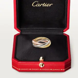 Side view of Cartier Trinity ring highlighting the fluid interlocking 18k gold bands and sparkle of the diamonds.