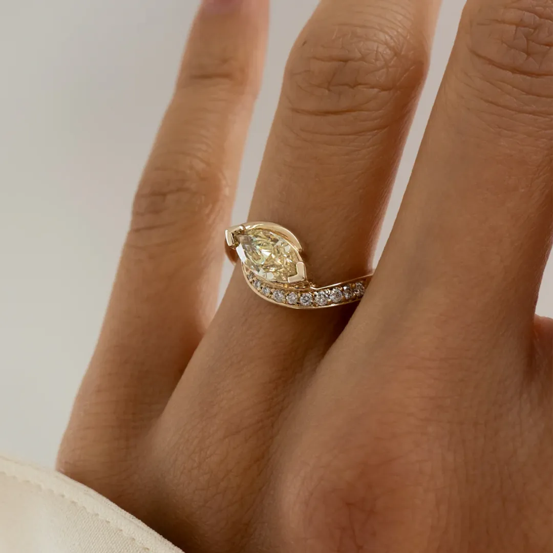 Top view of yellow diamond demi pavé ring on white background