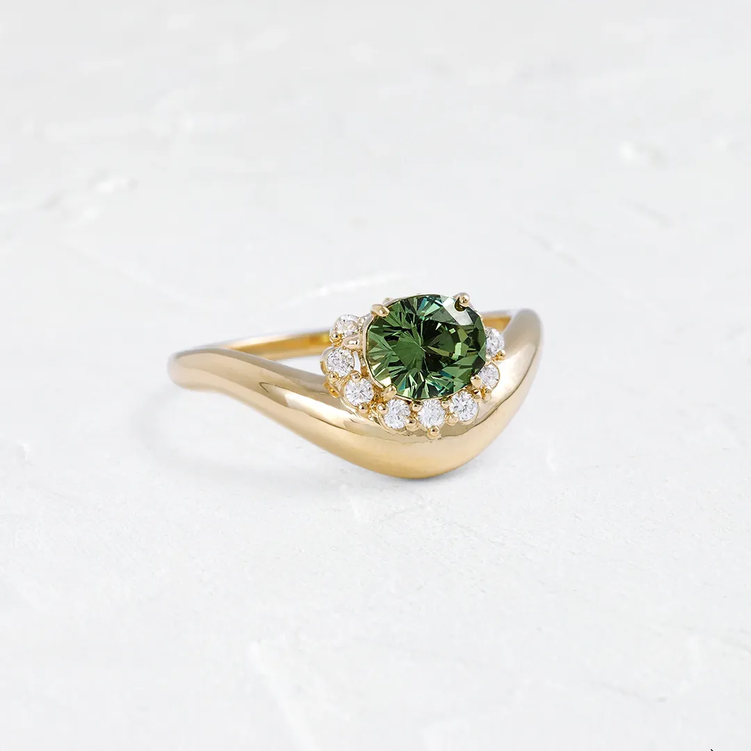 Top-down view of the Astronomer Ring highlighting the mint green demantoid garnet and the tenth hidden diamond beneath the setting.