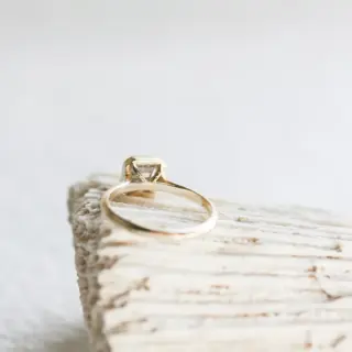Minimalist 14 kt recycled yellow gold ring featuring an Asscher‑cut salt and pepper diamond set in an open‑bottom cathedral bezel