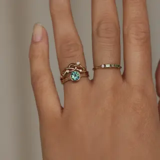 14k recycled yellow gold solitaire ring featuring a 1.0ct round brilliant cut bi-color blue-green sapphire (6.03–6.11mm), ethically sourced from Australia.